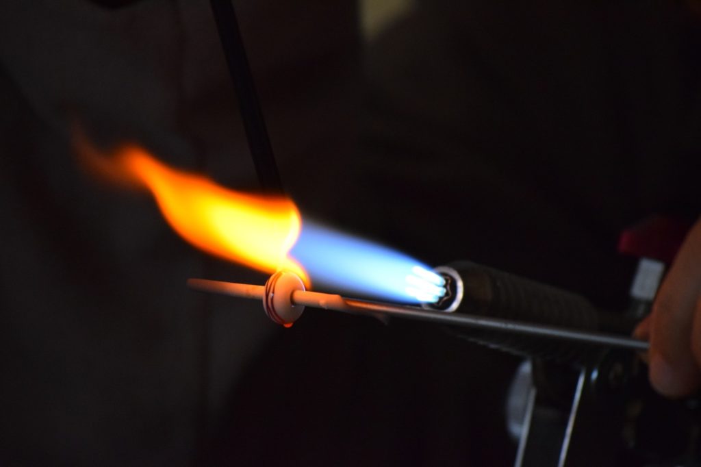 A blue and orange torch flame melting a stake.