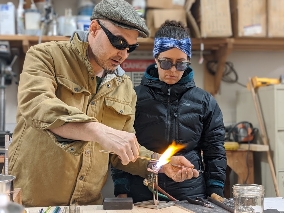 John providing hands-on help to a student trying to attach a cold punty in the torch.