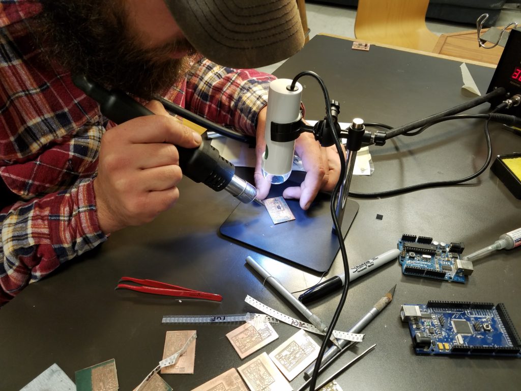 Brad Mendrick using a USB microscope to mount soldering parts to an Internet Service Provider (ISP).
