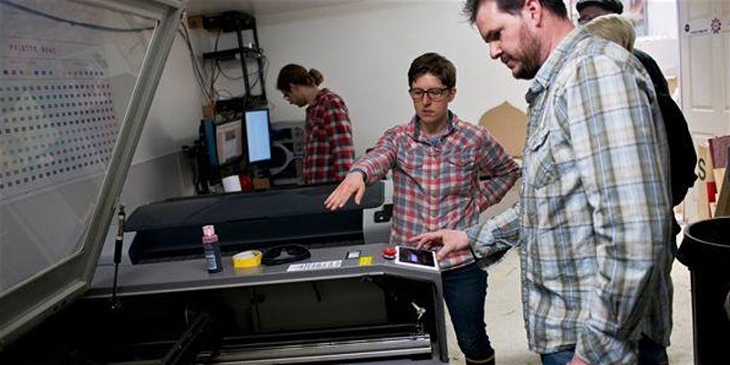 Jessica teaching the laser cutter class at Anchorage Makerspace in 2020 to a few students working within the workshop.