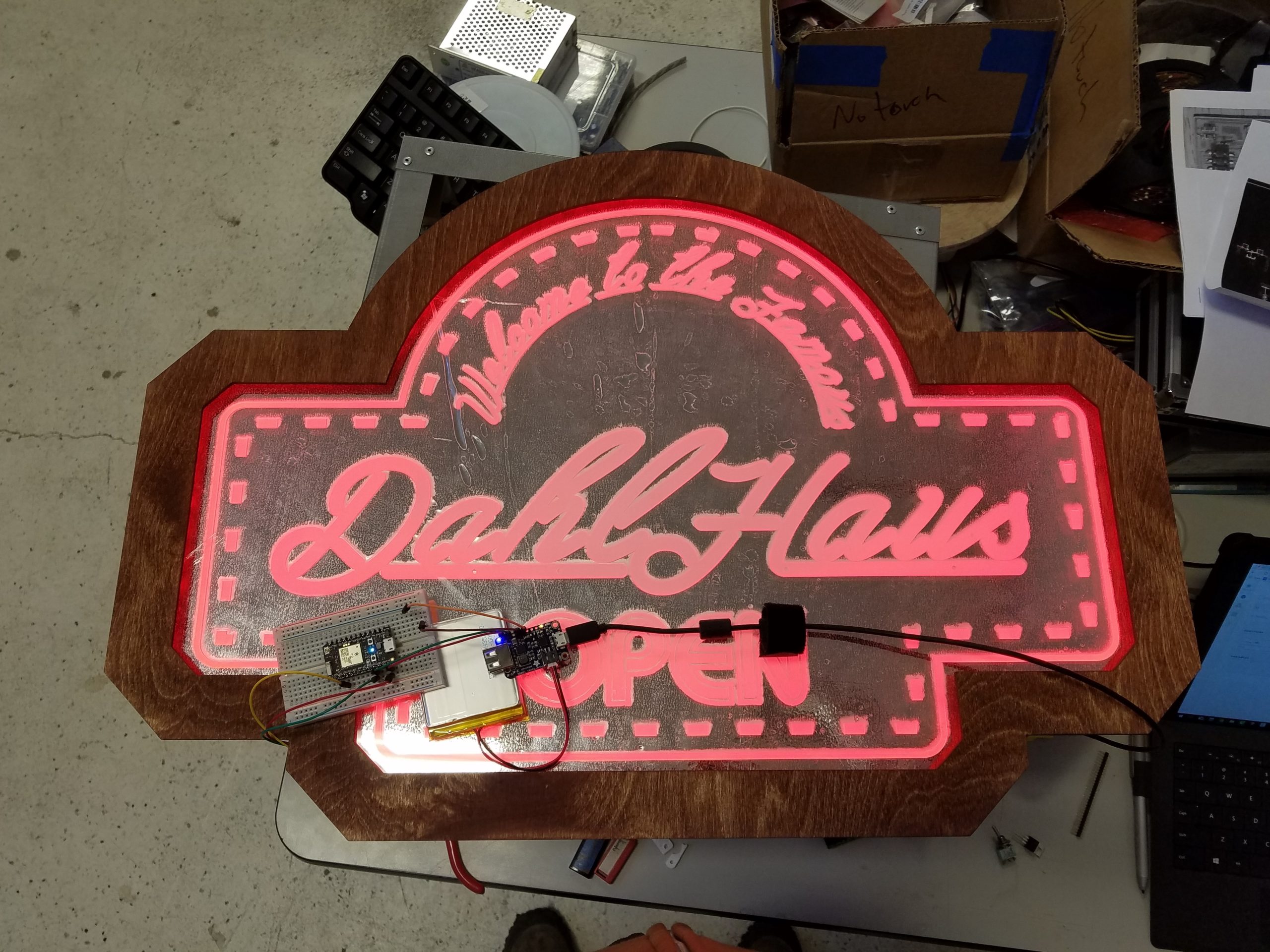 A top-down picture of the finished Dahl Haus sign showcasing red LEDs and the stained birch frame.